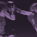 Kaksi nuorta aikuista nyrkkeilee nyrkkeilyhanskat käsissään.